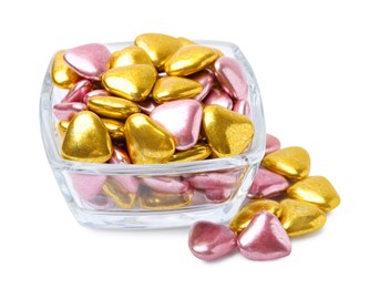 Glass bowl and many delicious heart shaped candies on white background