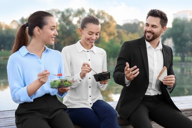Photo of Smiling business man talking with his colleagues during lunch outdoors