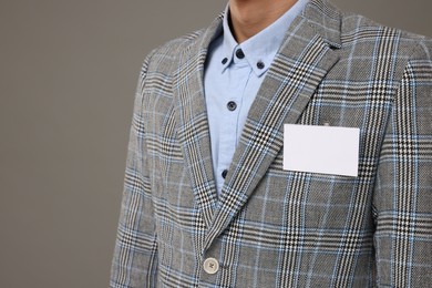 Man with blank badge on grey background, closeup