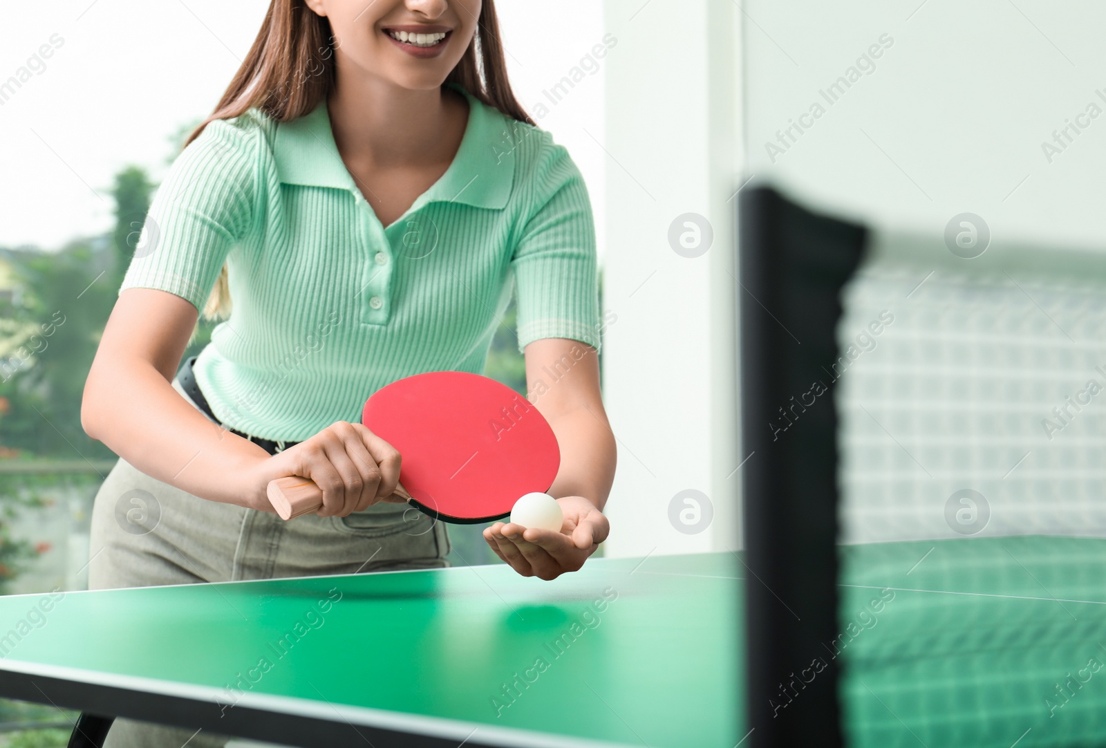 Photo of Woman playing ping pong indoors, closeup view. Space for text