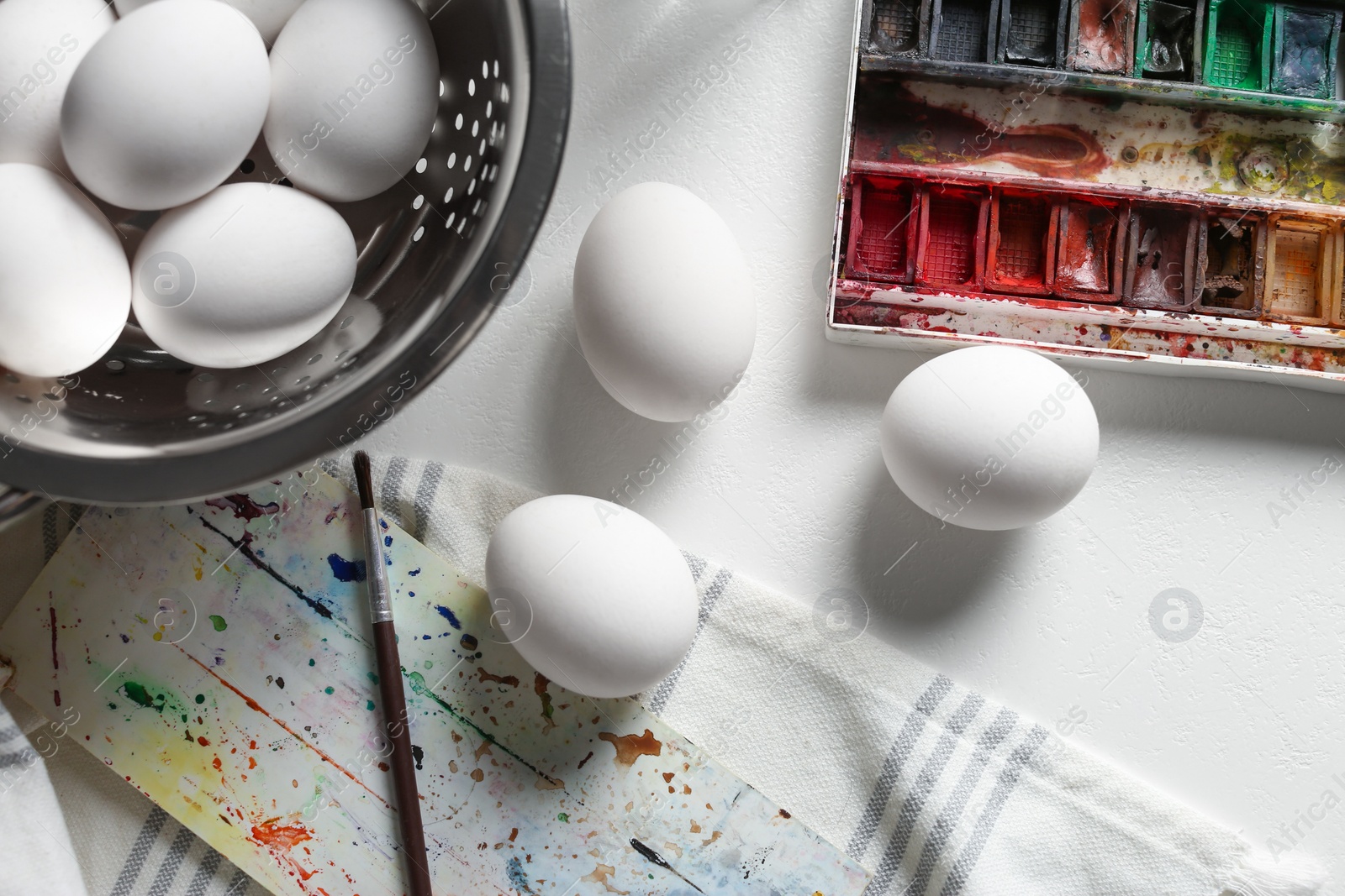 Photo of Painting Easter eggs on white table, flat lay