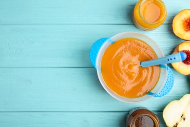 Flat lay composition with healthy baby food and ingredients on light blue wooden table. Space for text