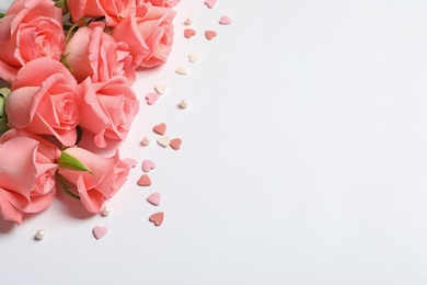 Photo of Beautiful roses and little hearts on white background