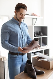 Young man choosing shoes in store