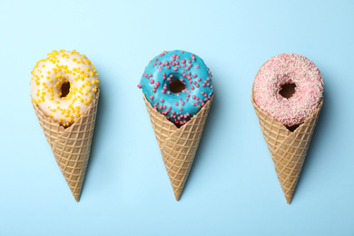 Photo of Ice cream made with donuts on light blue background, flat lay