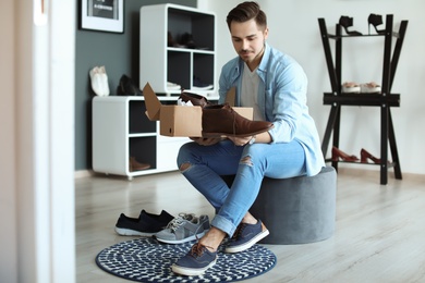 Photo of Young man choosing shoes in store