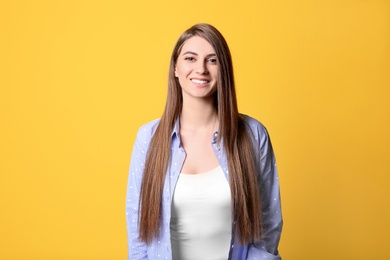 Portrait of young woman with long beautiful hair on color background