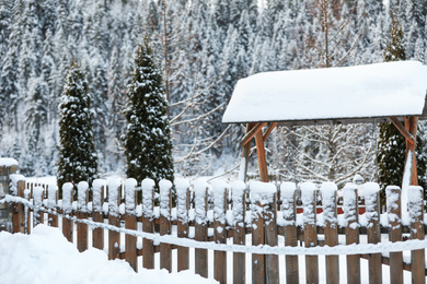 Wooden fence covered with snow outdoors. Winter vacation