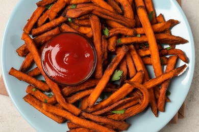 Photo of Delicious sweet potato fries served with sauce on table, closeup