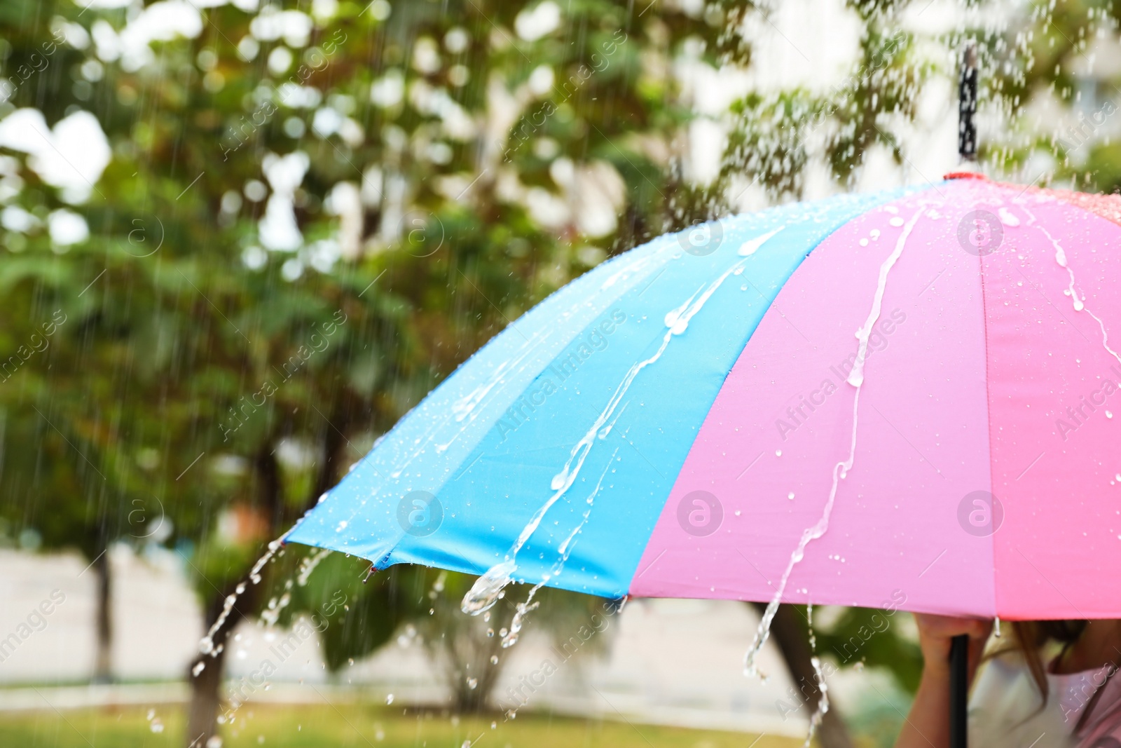 Photo of Person with bright umbrella under rain on street, closeup