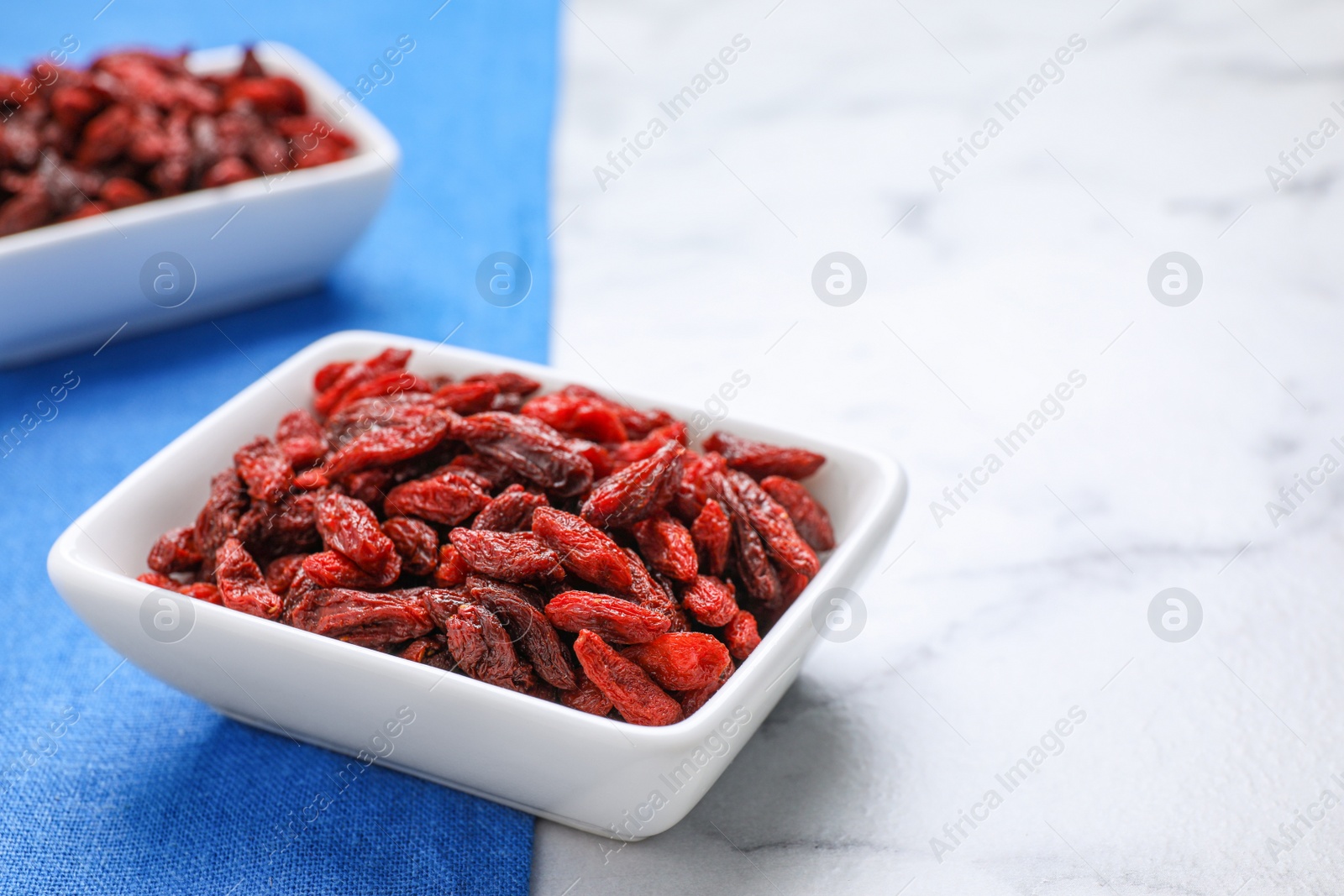 Photo of Dry goji berries on marble table, closeup