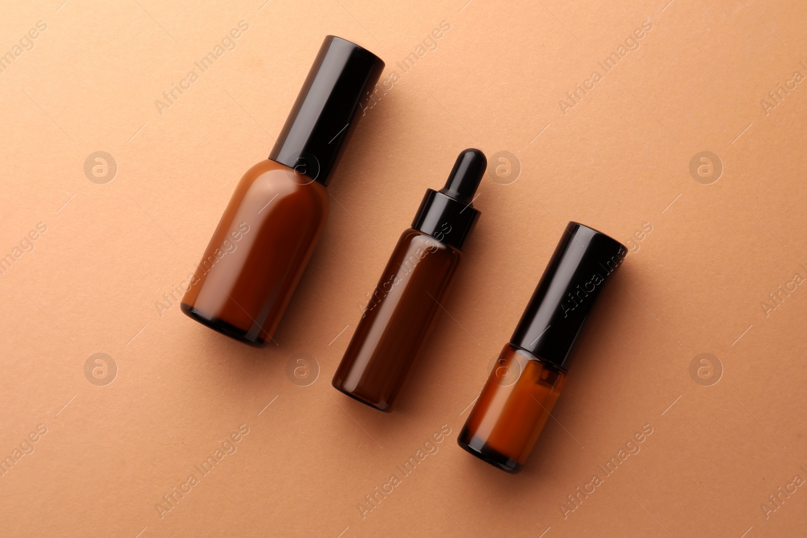 Photo of Bottles of face cream on beige background, flat lay