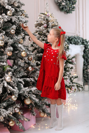 Cute little child near Christmas tree at home