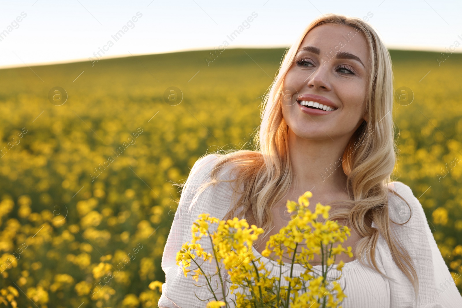 Photo of Portrait of happy young woman in field on spring day