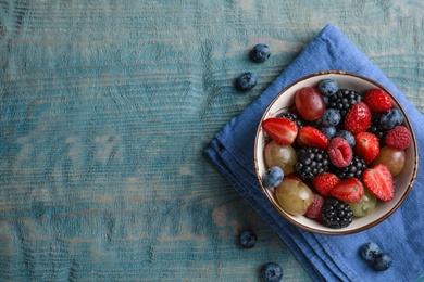 Photo of Fresh tasty fruit salad on blue wooden table, flat lay. Space for text