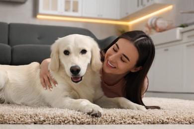 Photo of Happy woman with cute Labrador Retriever dog on floor at home. Adorable pet