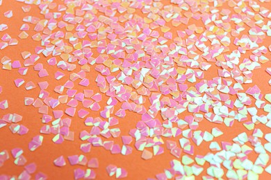 Photo of Shiny bright pink glitter on coral background