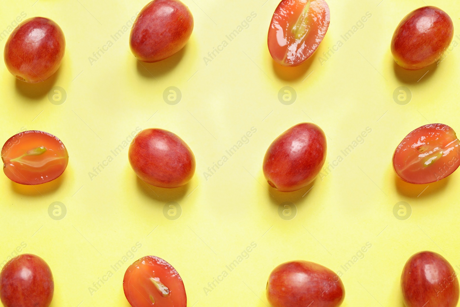 Photo of Flat lay composition with fresh ripe juicy grapes on yellow background