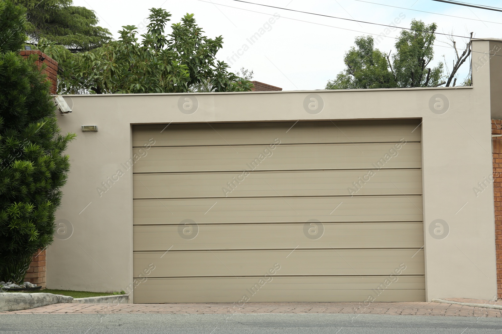 Photo of Beige garage with closed sectional door. Exterior design