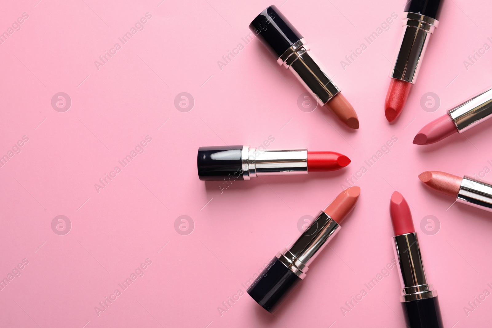 Photo of Flat lay composition with lipsticks and space for text on color background