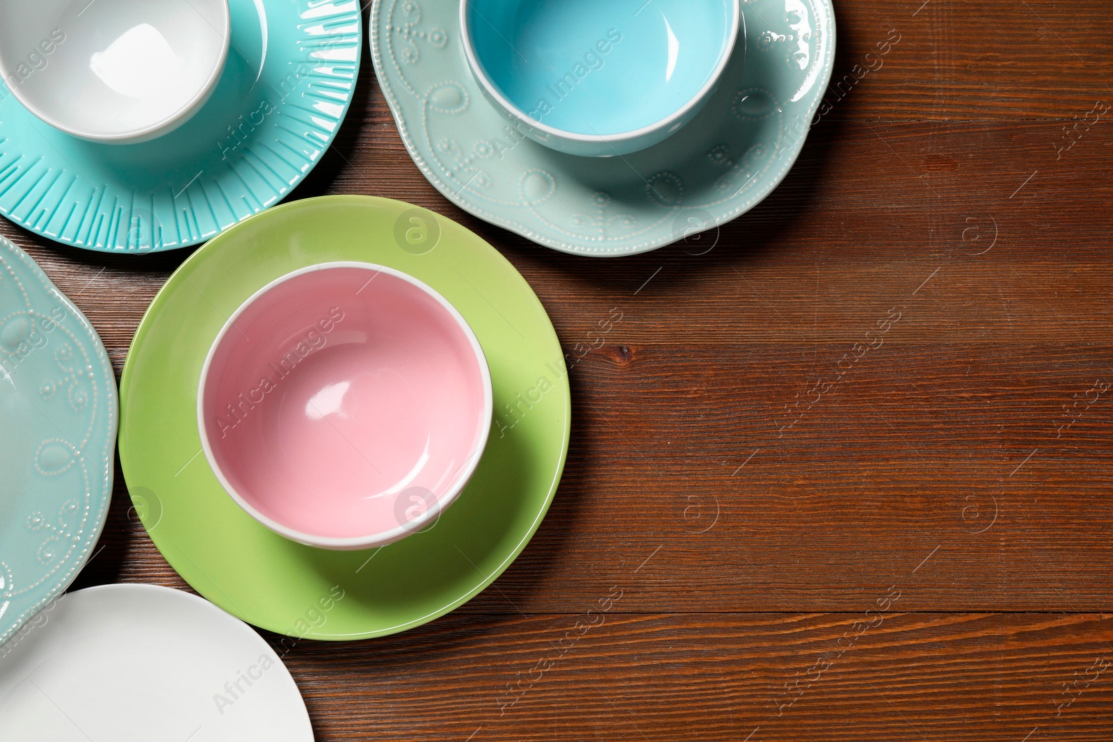 Photo of Beautiful ceramic dishware on wooden table, flat lay. Space for text