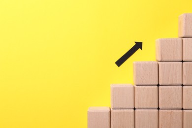 Photo of Business process organization and optimization. Scheme with wooden figures and arrow on yellow background, top view. Space for text