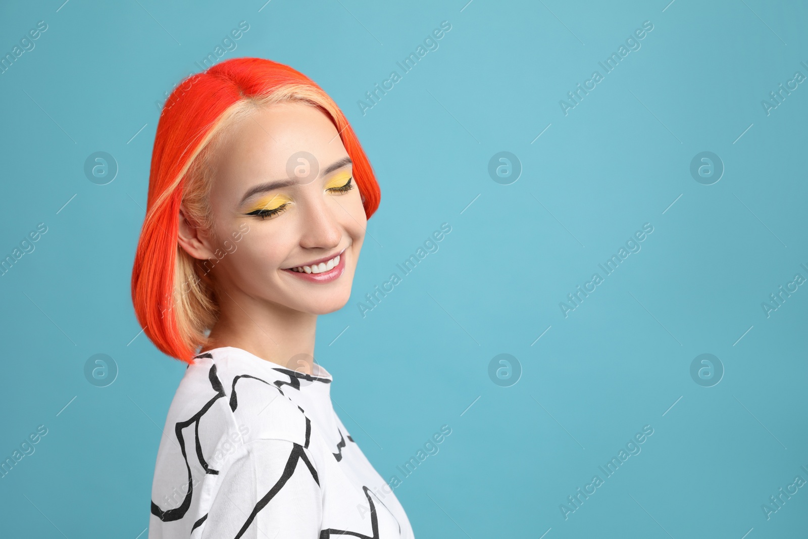 Photo of Beautiful young woman with bright dyed hair on turquoise background. Space for text