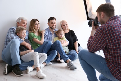 Photo of Professional photographer taking photo of family in studio