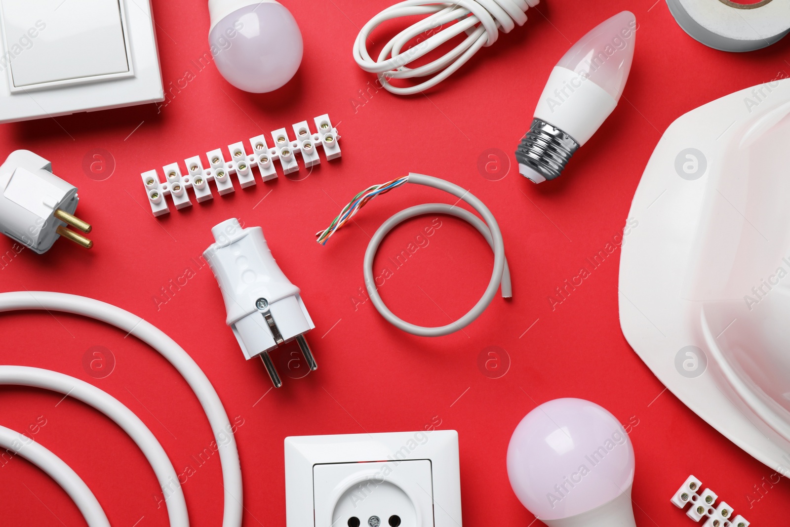 Photo of Flat lay composition with electrician's accessories on red background