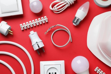 Flat lay composition with electrician's accessories on red background