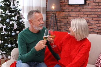 Mature couple with glasses of champagne at home. Christmas celebration