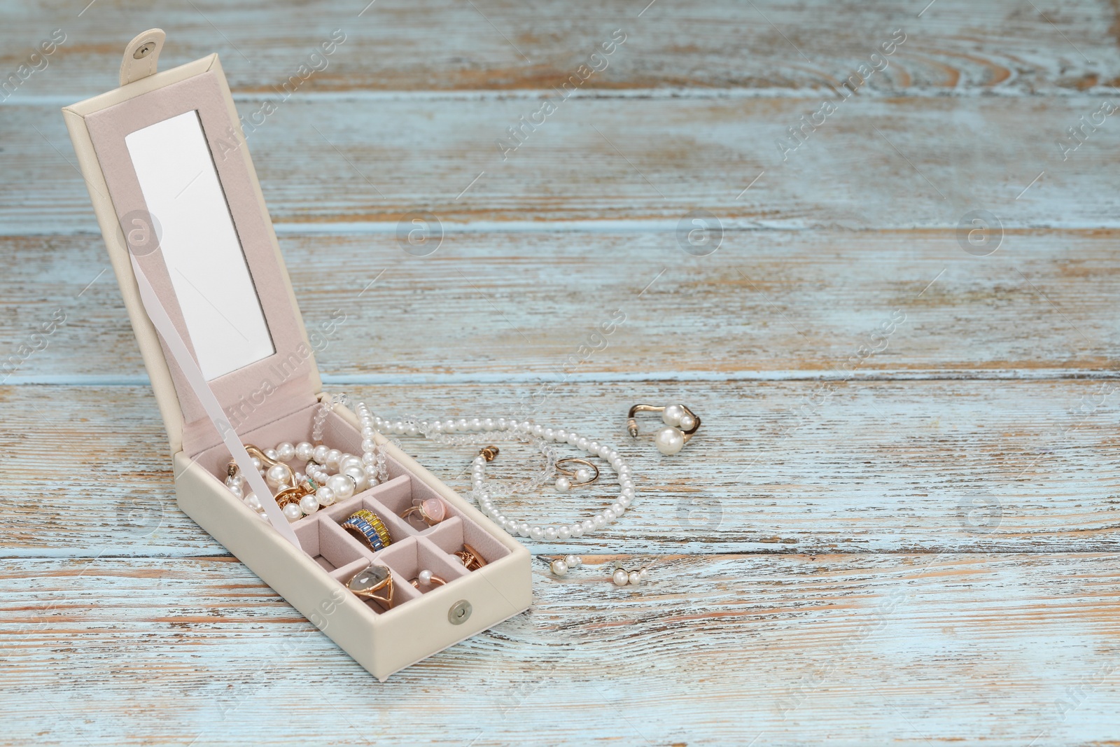 Photo of Jewelry box with many different accessories on rustic wooden table. Space for text