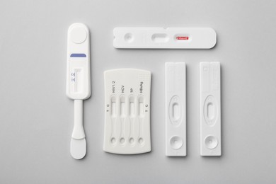 Photo of Different disposable express tests on light grey background, flat lay