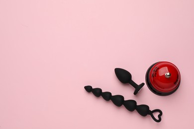 Sex toys and bell on pink background, flat lay. Space for text