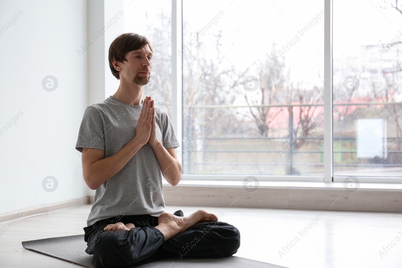 Photo of Young man practicing yoga indoors