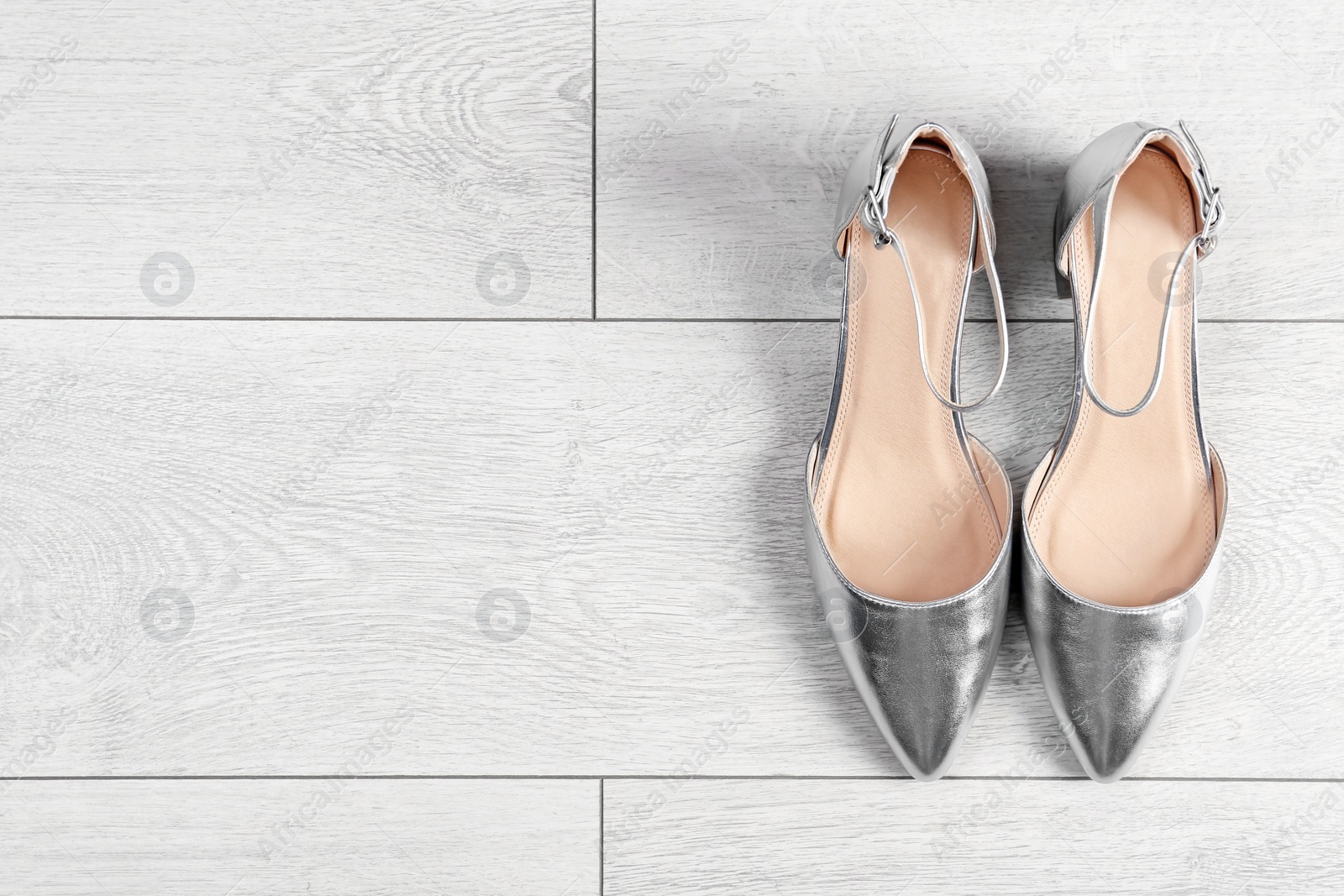 Photo of Pair of female shoes on wooden background, top view