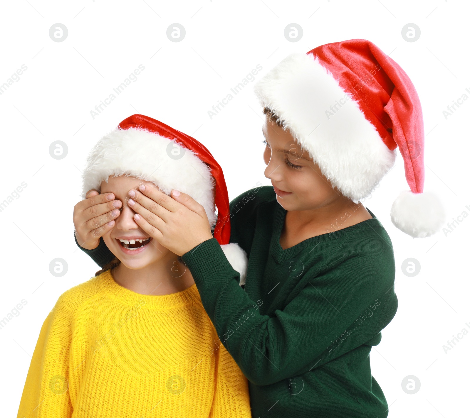 Photo of Happy little children in Santa hats on white background. Christmas celebration