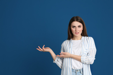 Photo of Portrait of emotional young woman on blue background