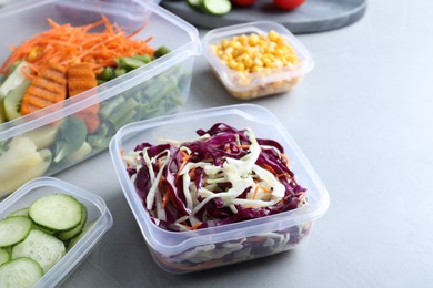 Photo of Set of plastic containers with fresh food on light table