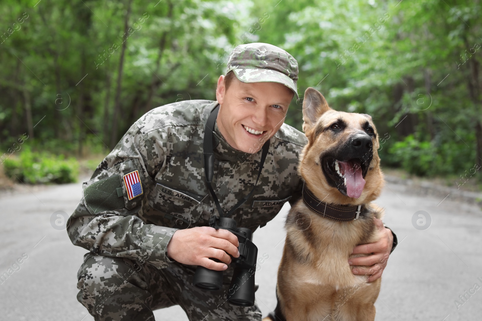 Photo of Man in military uniform with German shepherd dog, outdoors