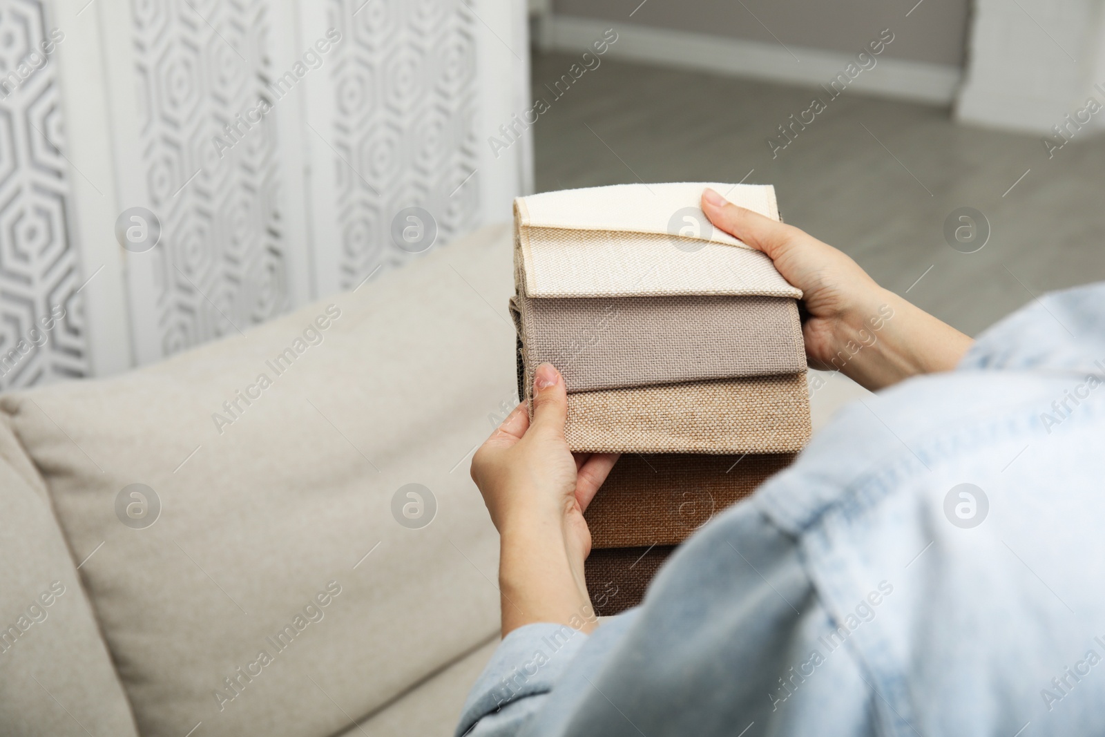 Photo of Woman choosing fabric among colorful samples at home, closeup. Space for text