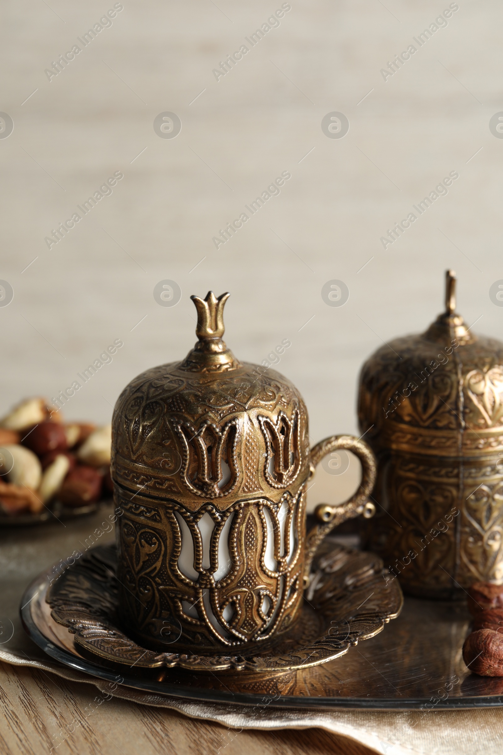 Photo of Tea and nuts served in vintage tea set on wooden table, space for text