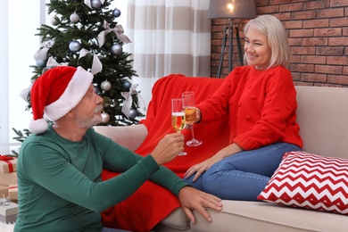 Mature couple with glasses of champagne at home. Christmas celebration