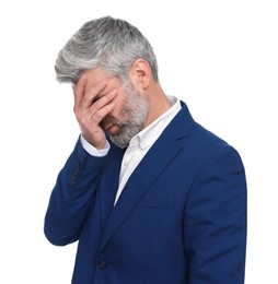 Mature businessman in stylish clothes covering his face with hand on white background