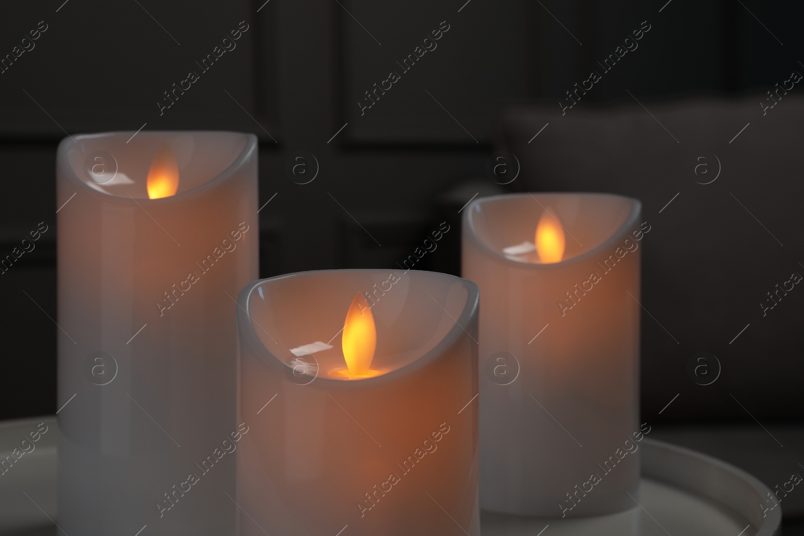 Photo of Decorative LED candles on white table indoors