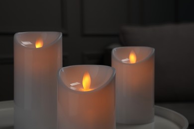 Photo of Decorative LED candles on white table indoors