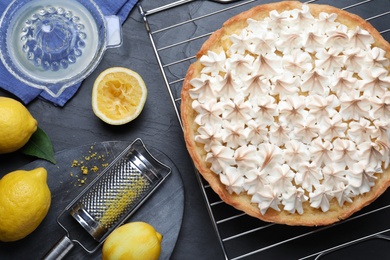 Photo of Flat lay composition with delicious lemon meringue pie on black table