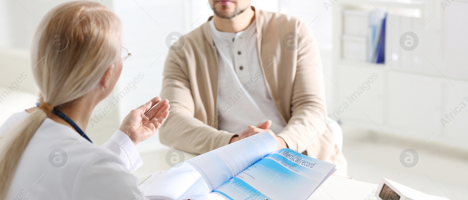 Image of Closeup view of doctor consulting patient at desk in clinic. Banner design