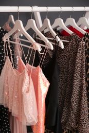 Wardrobe rack with women's clothes on dark background