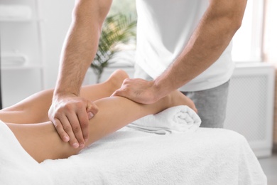 Photo of Young woman receiving massage in salon, closeup